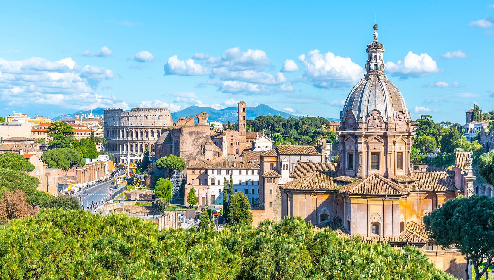 Rome skyline with the Colosseum and historic architecture under a bright blue sky | MSC Cruises