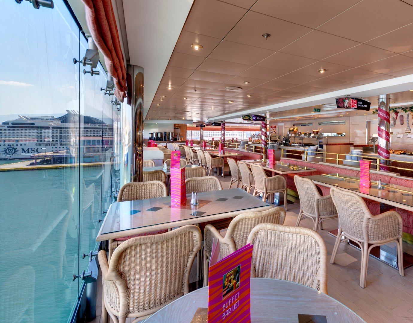 Buffet dining area with ocean views and MSC cruise ship docked nearby | MSC Cruises Buffet dining area with ocean views and MSC cruise ship docked nearby | MSC Cruises